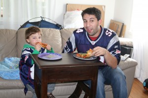 Avi and Daddy enjoy some pizza and football